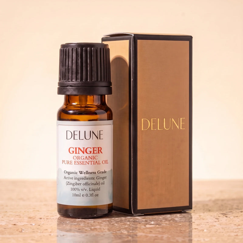 Huile essentielle biologique de gingembre Delune, flacon de 10 ml en verre ambré avec son coffret-cadeau Delune à dorure sur pierre de travertin chaude