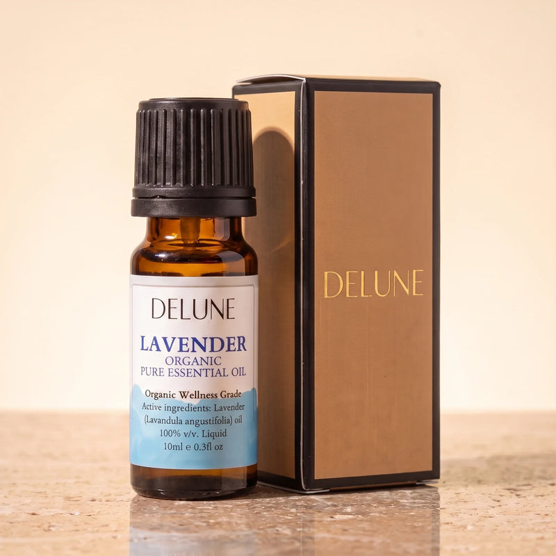 Huile essentielle biologique de lavande Delune, flacon de 10 ml en verre ambré avec son coffret-cadeau Delune à dorure sur pierre de travertin chaude