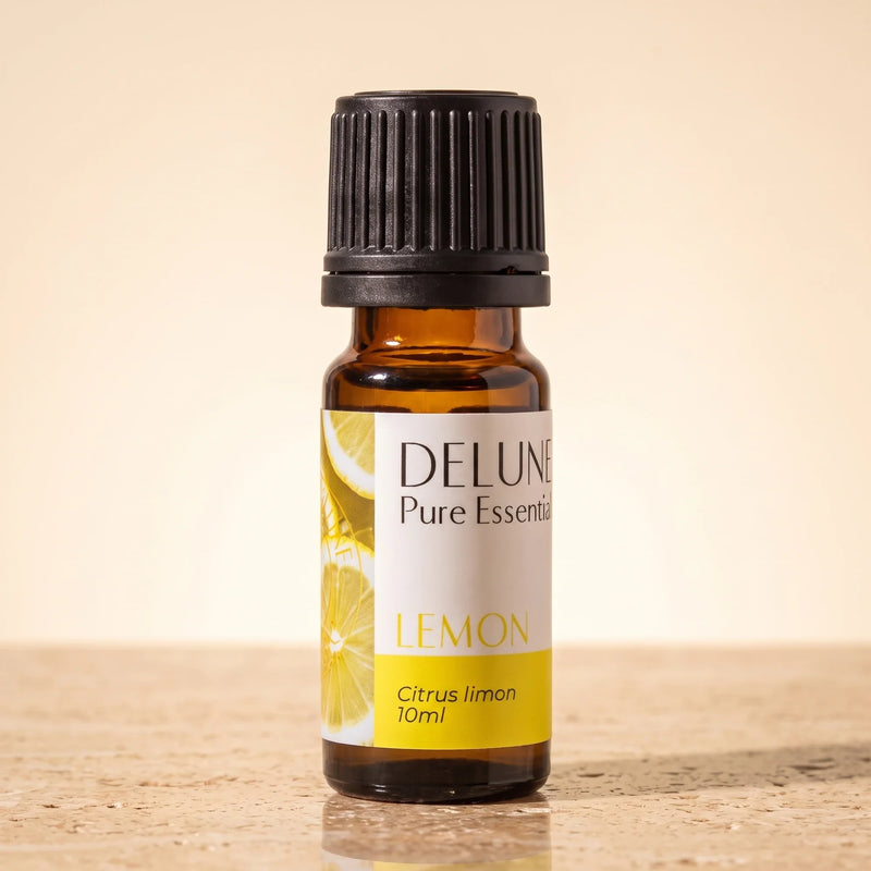 Delune Lemon Pure Essential Oil, 10ml amber glass bottle on warm travertine stone